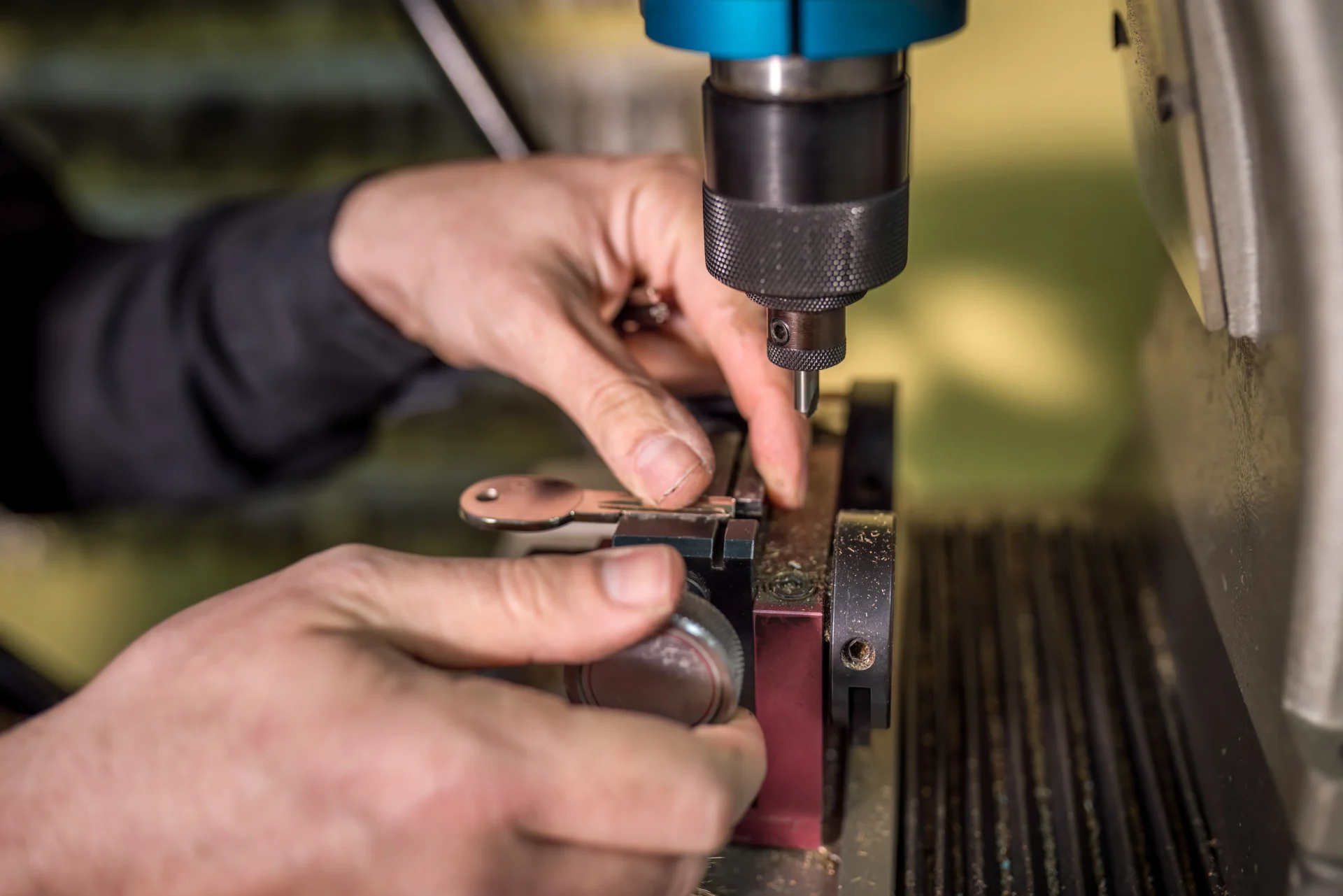 Hands operating a precision metalworking machine.